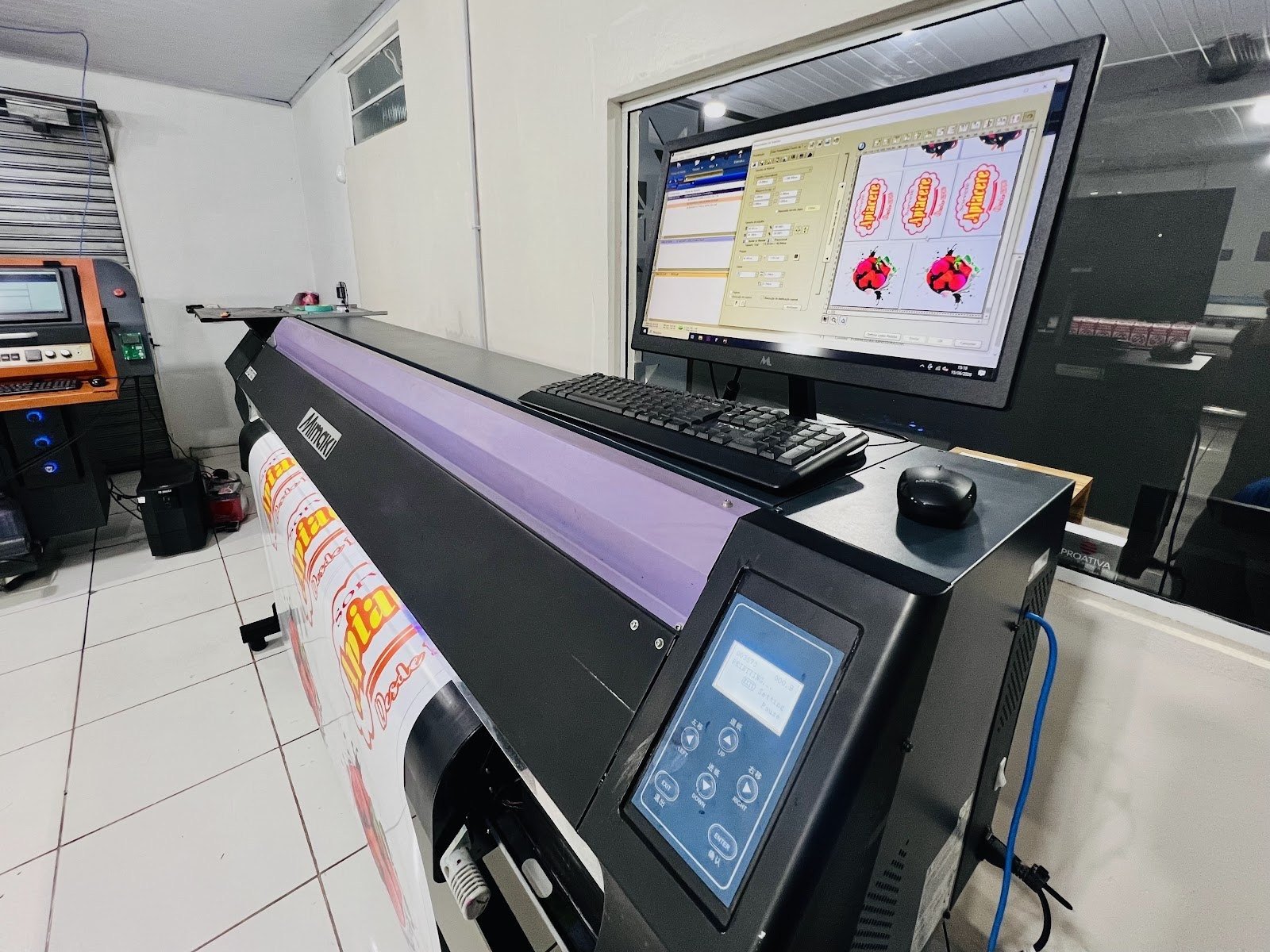 Estação de pré-impressão da Insight com monitor de conferência de arte ao lado da impressora